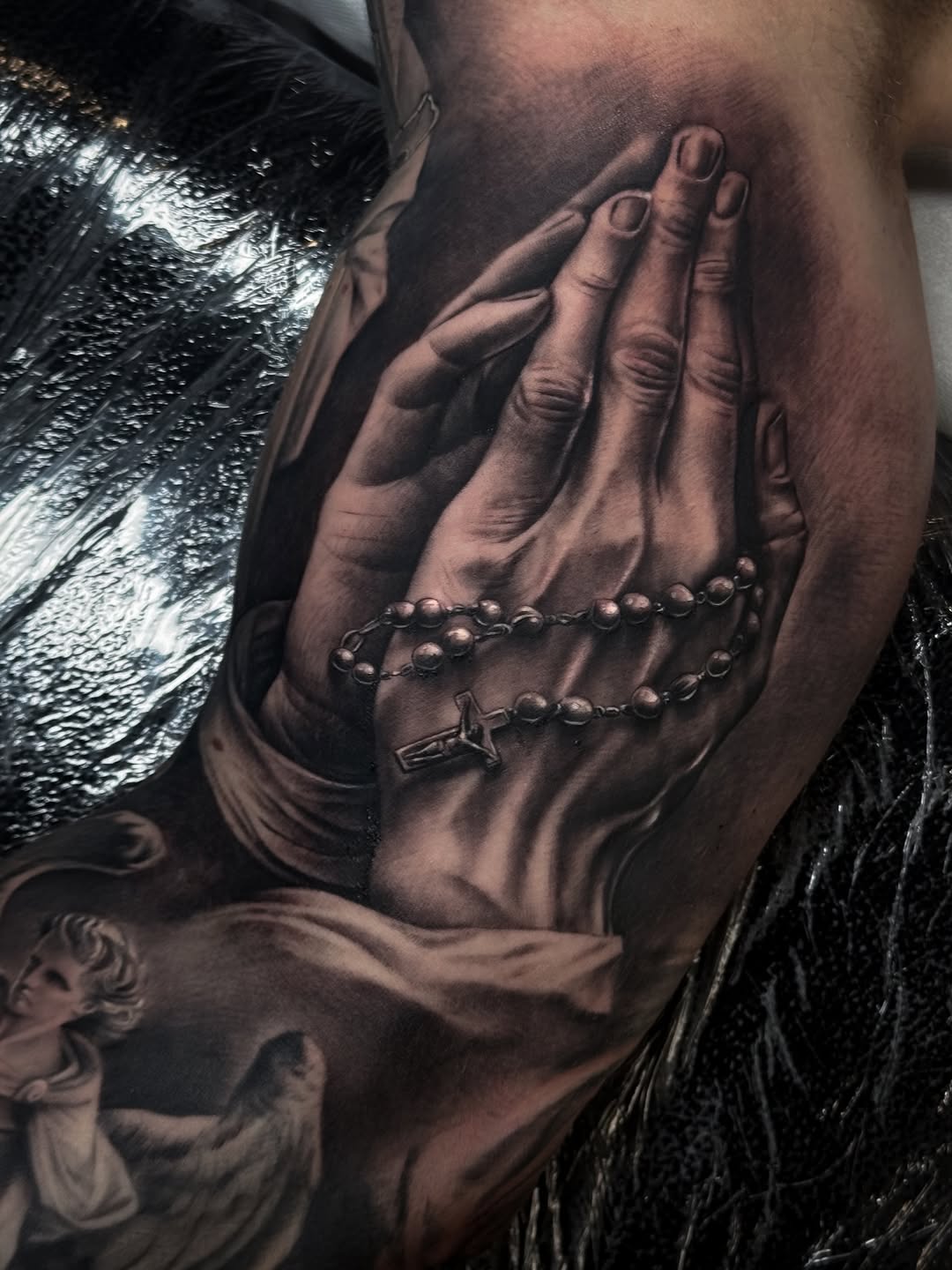 Modlące się dłonie z różańcem — biceps
